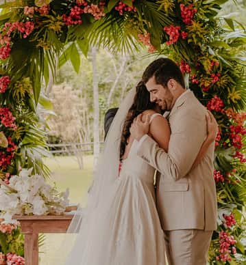 Casal abraçado sob arco de flores, cerimônia de casamento ao ar livre Bride's Dream