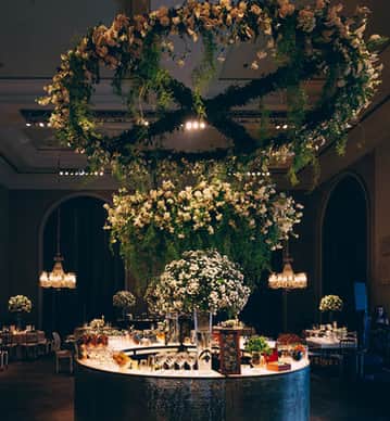 Ornamentação floral no grande salão do Palácio Tangará, com lustres, flores e elegância na festa.