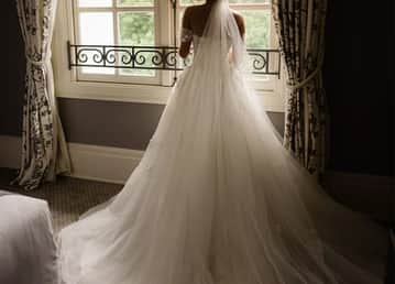 Noiva de vestido e véu olhando pela janela do Hotel Palácio Tangará. Bride's Dream